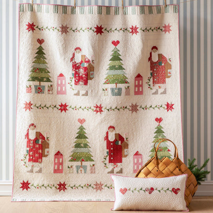 Decorative towel with Christmas-themed design featuring Santa Claus, trees, and houses on a striped wall background.
