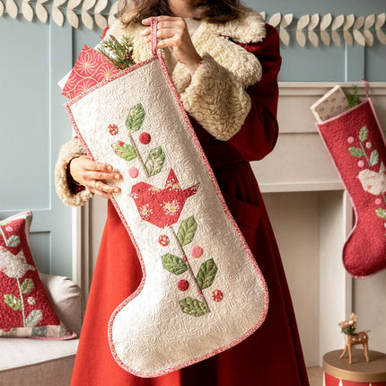 Woman holding a red and white Christmas stocking with a festive background